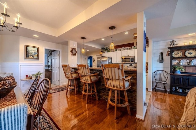 dining room with dark hardwood / wood-style flooring and a raised ceiling