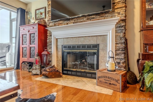 sitting room featuring plenty of natural light, wood-type flooring, and a tile fireplace