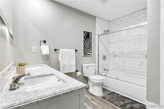 full bathroom with hardwood / wood-style flooring, vanity, toilet, and tiled shower / bath