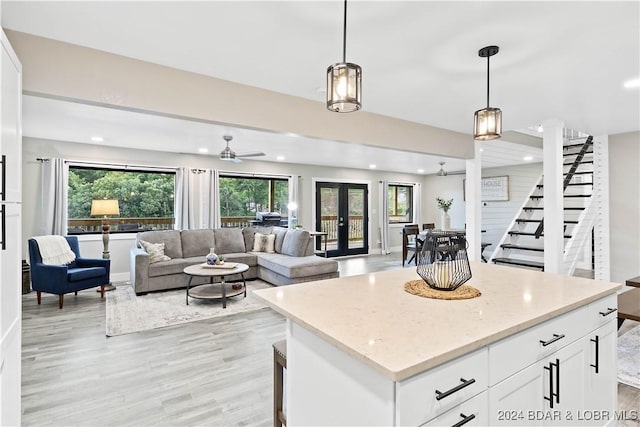 kitchen with white cabinetry, hanging light fixtures, and a healthy amount of sunlight