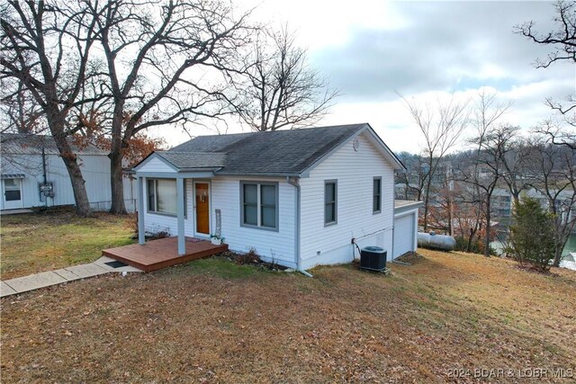 bungalow-style home featuring central air condition unit, a front lawn, and a deck