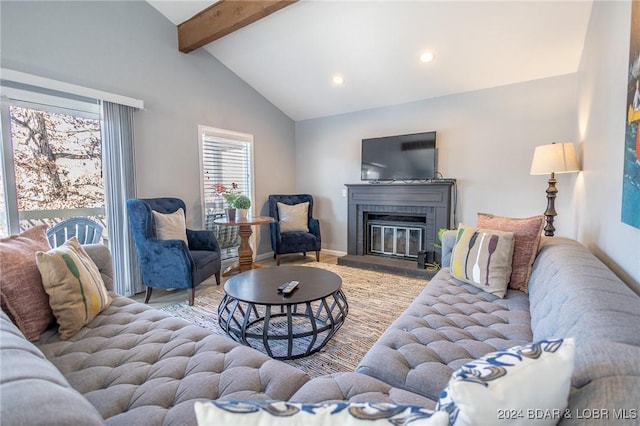 living room with a fireplace, beamed ceiling, and high vaulted ceiling