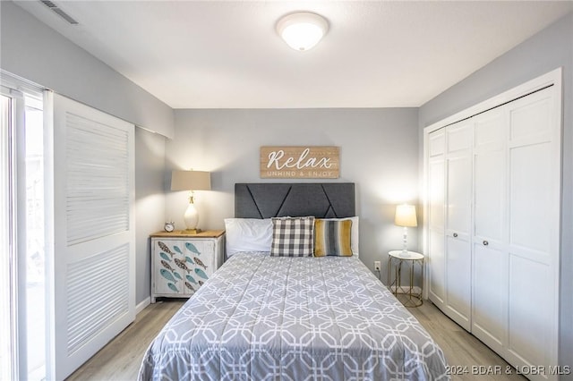 bedroom with light hardwood / wood-style floors and a closet