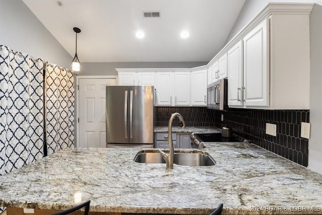 kitchen featuring appliances with stainless steel finishes, tasteful backsplash, vaulted ceiling, and sink