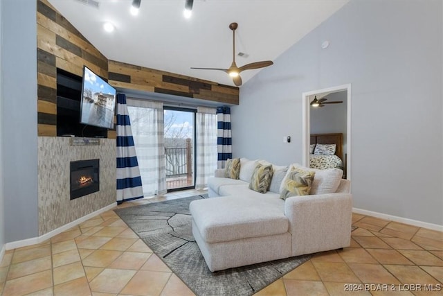 living room featuring ceiling fan, light tile patterned flooring, high vaulted ceiling, and a tiled fireplace