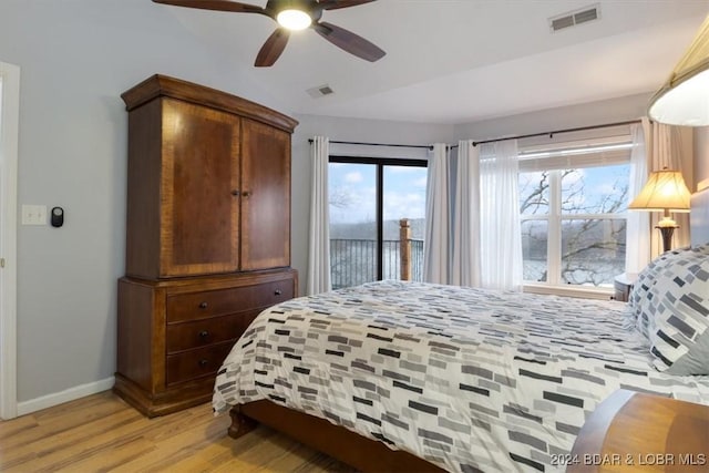 bedroom with access to exterior, light wood-type flooring, multiple windows, and ceiling fan