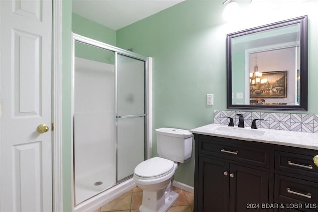 bathroom featuring tile patterned floors, decorative backsplash, vanity, and a shower with shower door