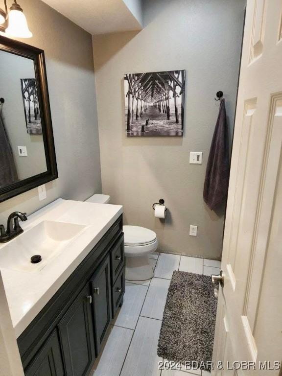 bathroom featuring tile patterned floors, vanity, and toilet