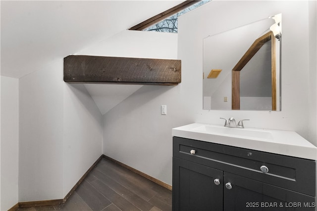 bathroom with vanity, lofted ceiling, and hardwood / wood-style flooring