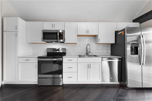 kitchen featuring lofted ceiling, sink, dark hardwood / wood-style floors, white cabinetry, and stainless steel appliances