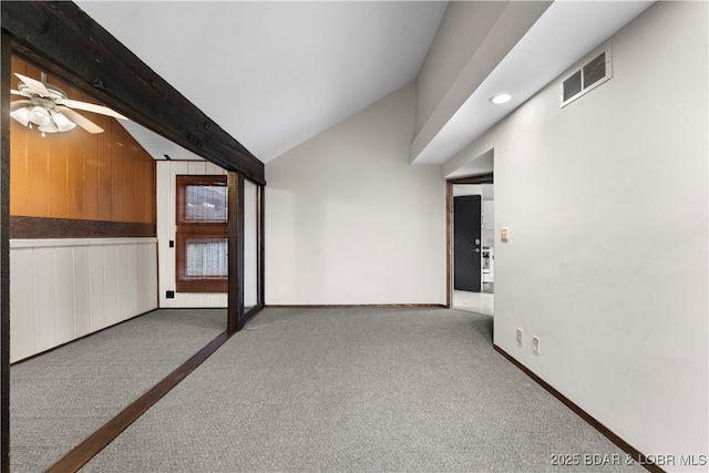 additional living space with vaulted ceiling with beams, ceiling fan, light colored carpet, and wooden walls