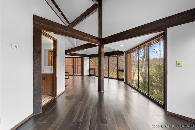 unfurnished sunroom with vaulted ceiling with beams