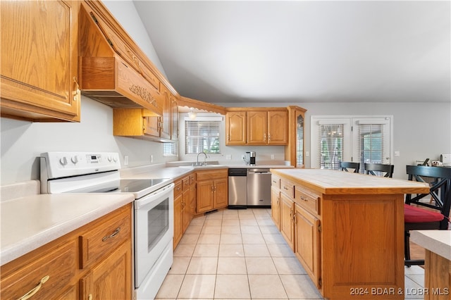 kitchen featuring a center island, white range with electric cooktop, stainless steel dishwasher, plenty of natural light, and light tile patterned flooring