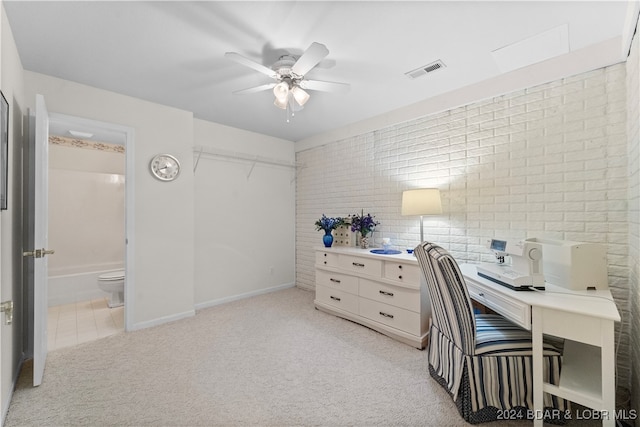 office with light colored carpet, ceiling fan, and brick wall