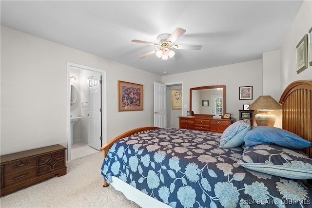 bedroom featuring light colored carpet, ensuite bath, and ceiling fan