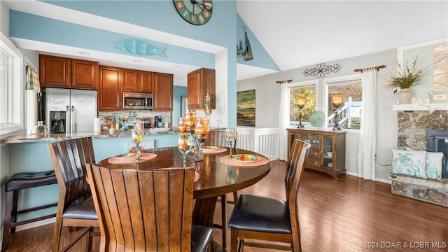 dining space with dark hardwood / wood-style flooring and vaulted ceiling