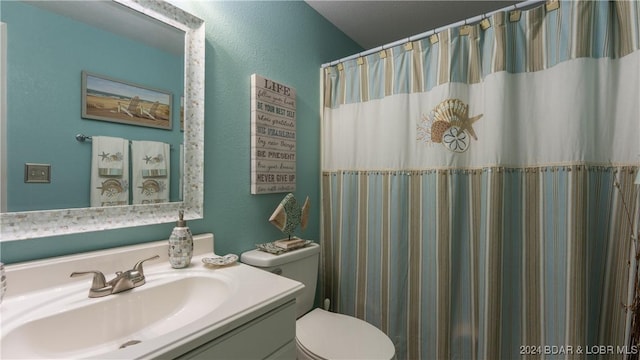 bathroom featuring curtained shower, vanity, and toilet