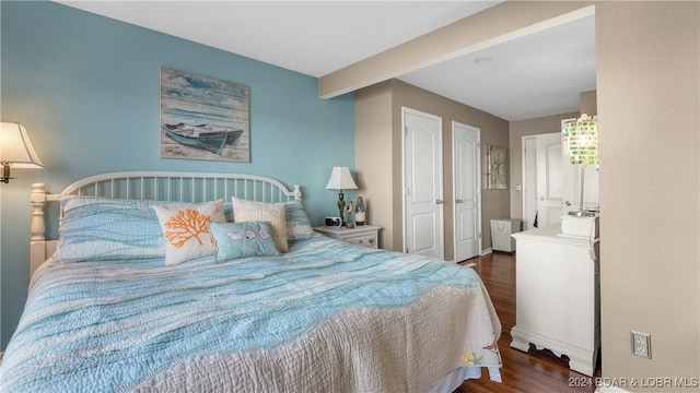 bedroom with beamed ceiling and dark wood-type flooring