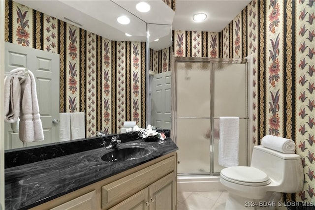 bathroom featuring tile patterned floors, vanity, toilet, and walk in shower