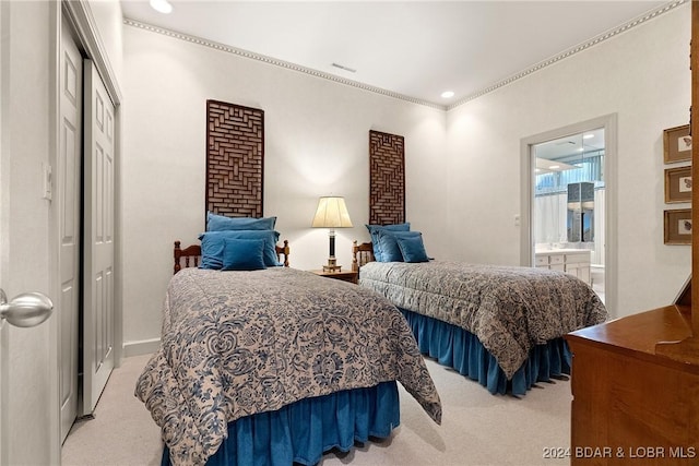 bedroom with light colored carpet and ensuite bath