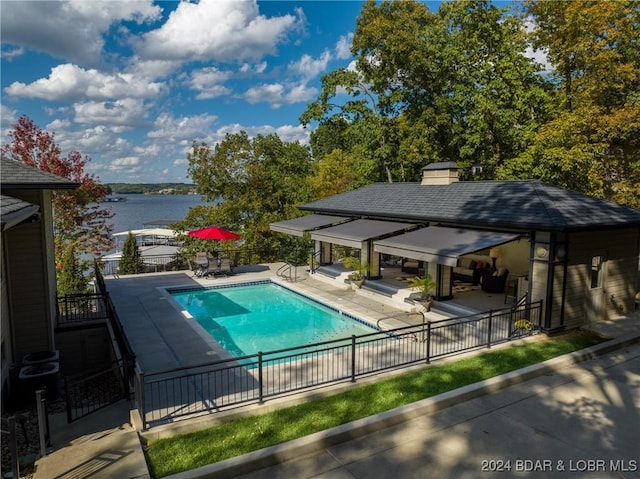 view of swimming pool featuring a patio area and a water view