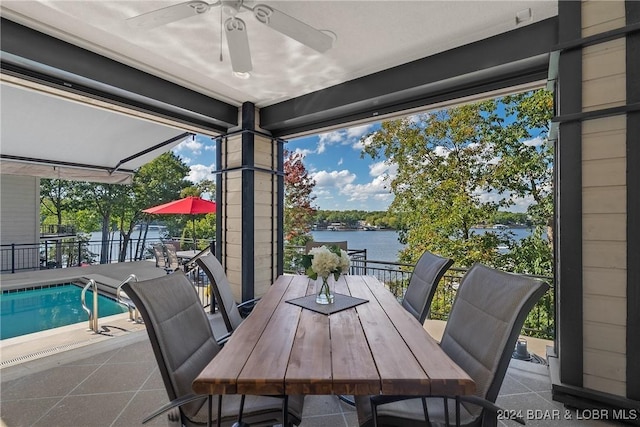 sunroom / solarium with a water view and ceiling fan