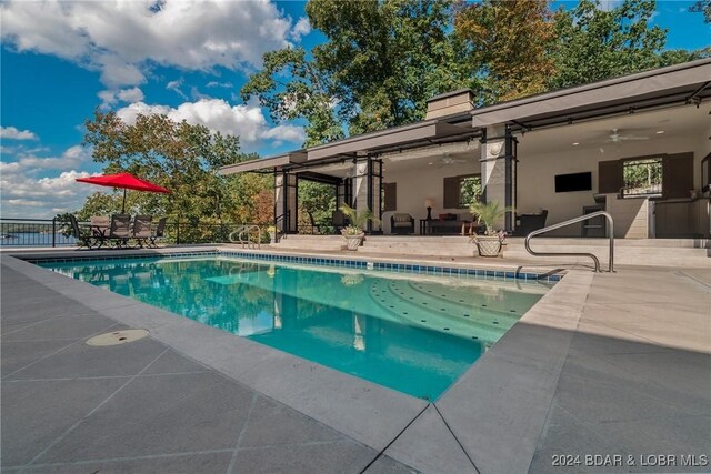 view of swimming pool featuring ceiling fan and a patio