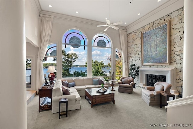 living room featuring light carpet, a water view, and ceiling fan