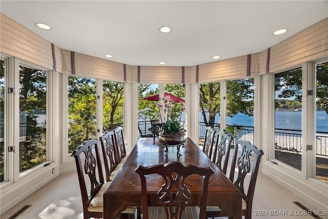 sunroom featuring a water view