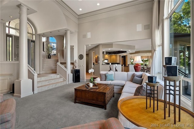 living room with carpet floors, crown molding, and a high ceiling