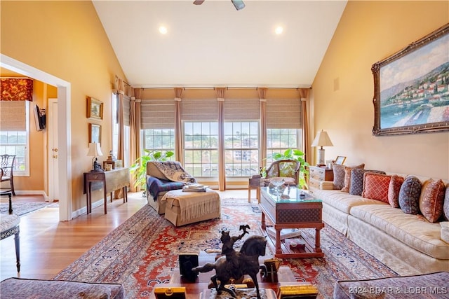 living room with ceiling fan, light wood-type flooring, and high vaulted ceiling