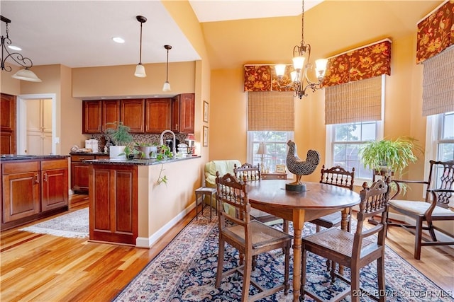 dining area with light hardwood / wood-style floors and a notable chandelier