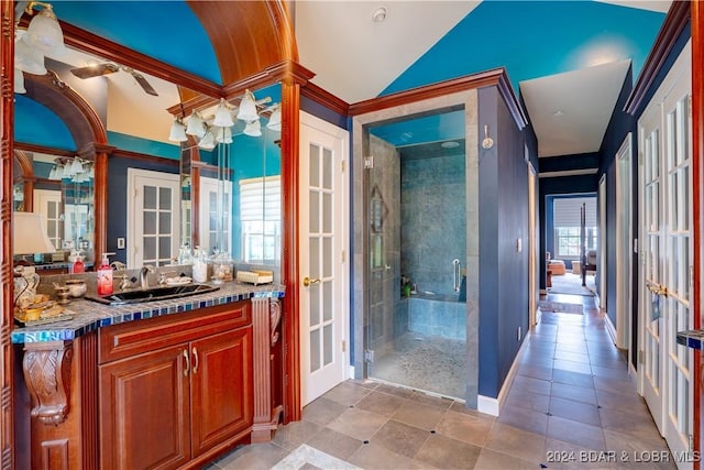 bathroom featuring a wealth of natural light, a shower with door, vanity, and lofted ceiling