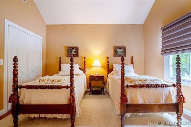 bedroom with light carpet, a closet, and lofted ceiling