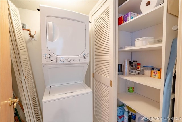 clothes washing area featuring stacked washer and clothes dryer