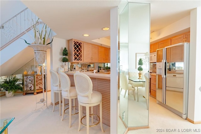 bar with white microwave, fridge with ice dispenser, wet bar, and recessed lighting