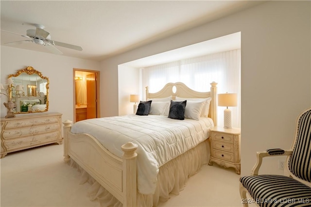 bedroom featuring light carpet, ceiling fan, and ensuite bathroom