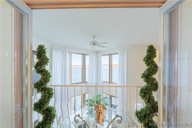 sunroom with a water view and ceiling fan