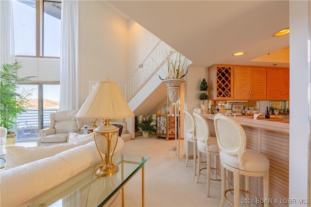 carpeted living room with recessed lighting and bar