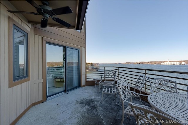 balcony with a water view and ceiling fan