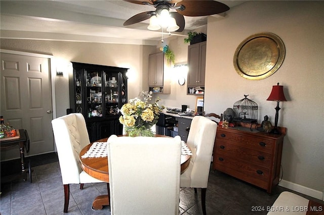 dining room with dark tile patterned flooring and ceiling fan