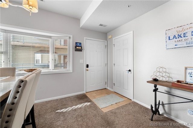 view of carpeted foyer entrance