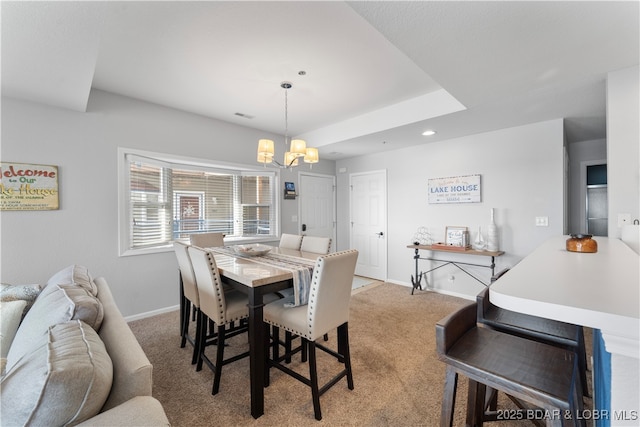 carpeted dining area with a chandelier