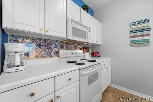 kitchen featuring white appliances, white cabinetry, and backsplash