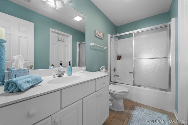 full bathroom featuring vanity, toilet, and bath / shower combo with glass door