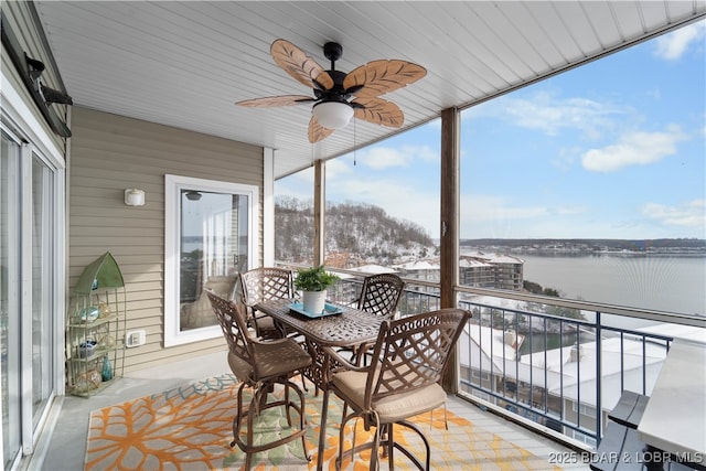 sunroom / solarium featuring a water view and ceiling fan