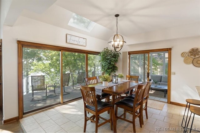 dining area with light tile patterned floors, an inviting chandelier, and vaulted ceiling with skylight