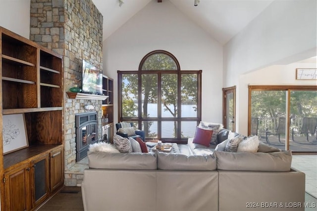 living room featuring a fireplace, high vaulted ceiling, and plenty of natural light