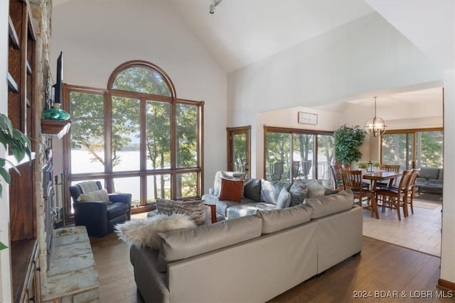 living room featuring dark hardwood / wood-style flooring, high vaulted ceiling, and a chandelier