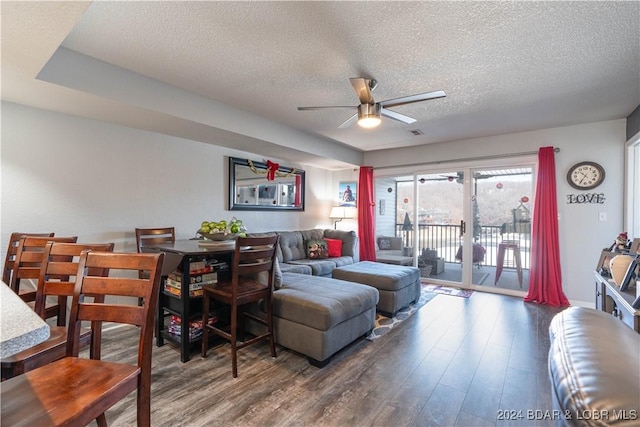 living room with ceiling fan, wood-type flooring, and a textured ceiling